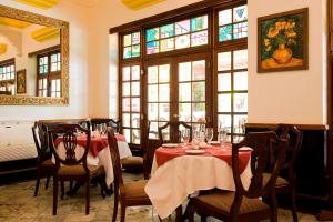 a dining room with tables and chairs and windows at Protea Hotel by Marriott Dar es Salaam Courtyard in Dar es Salaam