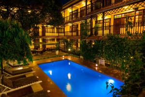 uma piscina em frente a um edifício à noite em Protea Hotel by Marriott Dar es Salaam Courtyard em Dar es Salaam