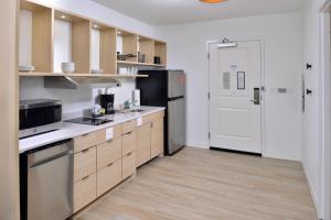 a kitchen with wooden cabinets and a refrigerator at TownePlace Suites by Marriott Asheville Downtown in Asheville