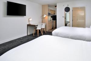 アッシュビルにあるTownePlace Suites by Marriott Asheville Downtownのベッド2台とデスクが備わるホテルルームです。