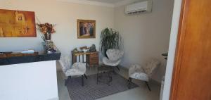 a room with four chairs and a table and a desk at Trindade Hotel in Trindade