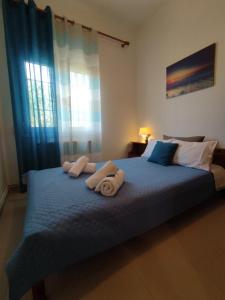 a bedroom with a large bed with towels on it at Kritharia Guesthouse Volos in Kritharia