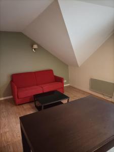 a living room with a red couch and a table at Appartement Le Montagnard in Les Déserts