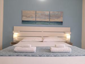 1 dormitorio con 1 cama grande y 2 almohadas blancas en Iris Rooms en Cagliari