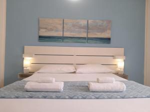 um quarto com uma cama grande e 2 almofadas brancas em Iris Rooms em Cagliari