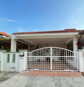 um portão branco em frente a uma casa em Cozy 119 Homestay Teluk Intan em Teluk Intan