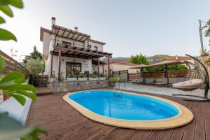 una piscina en una terraza con una casa en Villa Fylira, en Kato Gatzea
