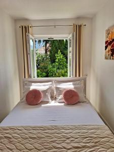 1 dormitorio con 1 cama con 2 almohadas y ventana en Apartment Ivy en Mlini