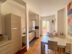 een keuken en een woonkamer met een tafel en een koelkast bij Maison de Amelie in Verona