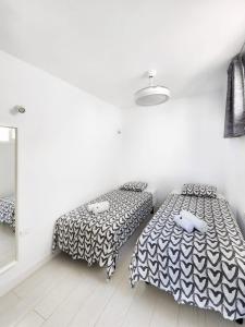 - 2 lits dans une chambre aux murs blancs dans l'établissement Atlantic Mirage Island Village, à Adeje