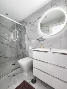 a bathroom with a sink toilet and a mirror at Atlantic Mirage Island Village in Adeje