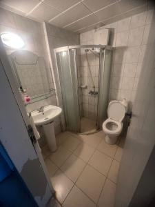 a bathroom with a shower and a toilet and a sink at EGE APART HOTEL in Marmaris