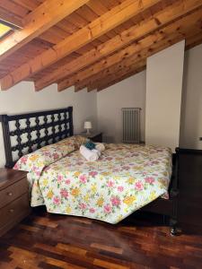 a bedroom with a bed and a wooden ceiling at Appartamento Sonia in Gravedona