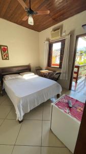 a bedroom with a bed and a ceiling fan at Pousada Cores Do Mar in Paraty