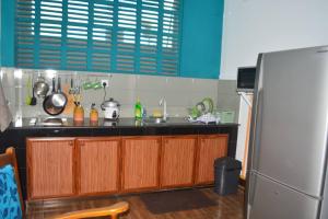 a kitchen with a sink and a refrigerator at Paramount Residence 3 in Kelaniya