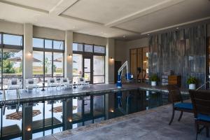 a pool in a house with chairs and tables at Renaissance Columbus Westerville-Polaris Hotel in Westerville