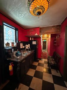 uma cozinha com paredes vermelhas e um piso xadrez em OQP Vacations Cottage em Miami