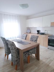 - une cuisine avec une table en bois et des chaises dans l'établissement Apartmani Biba, à Novi Vinodolski