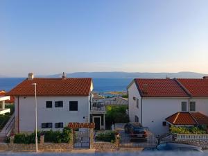 a view of a town with houses and the ocean at Apartmani Biba in Novi Vinodolski