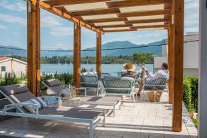 twee personen op een patio met uitzicht op het water bij Villa Gioia in Tivat