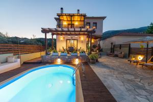 a swimming pool in a backyard with a house at Villa Fylira in Kato Gatzea