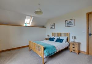 a bedroom with a large bed with blue pillows at Noyadd in Builth Wells