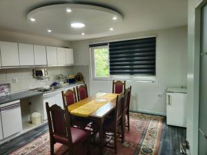 a kitchen with a wooden table and chairs and a window at Rooms Mery in Visoko