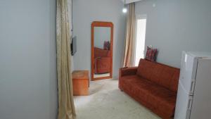 a living room with a red couch and a mirror at EGE APART HOTEL in Marmaris
