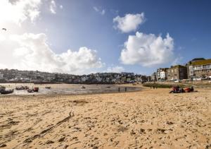 una spiaggia sabbiosa con barche in acqua e negli edifici di 9 Teetotal Street a St Ives