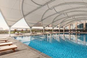 a large swimming pool with a canopy over it at Courtyard by Marriott Shunde Longjiang, Near Furniture Fair in Shunde