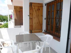 een tafel en stoelen op een veranda met een deur bij Inocencia in Alcossebre