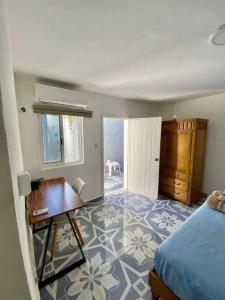 a bedroom with a desk and a bed and a table at Cozy apartment king bed ac downtown in Cozumel