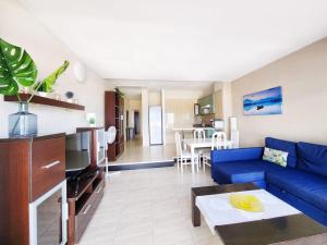 a living room with a blue couch and a kitchen at Ocean View Villas Canarias in Adeje