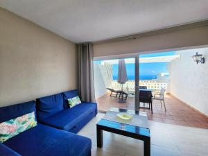 a living room with a blue couch and a table at Ocean View Villas Canarias in Adeje