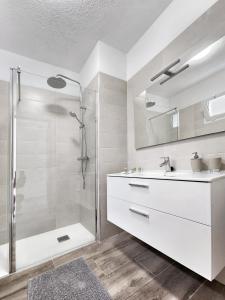 a white bathroom with a shower and a sink at Ocean View Villas Canarias in Adeje
