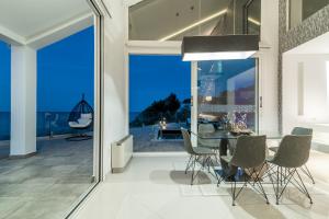 una sala da pranzo con tavolo e vista sull'oceano di Luxury Villa Cavo Mare Thalassa with private pool & jacuzzi a Plános