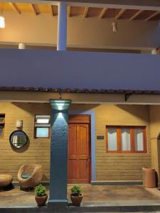 dom z niebieską kolumną i drewnianymi drzwiami w obiekcie Sierra Norte By Chic Hotel Group w mieście Tepoztlán