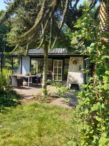 a house with a table and a bench in a yard at Natuurhuisje Eartswoud in Aartswoud