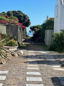 a stone path leading to a house with a fence at Bougain Villa Studio 1 in Paternoster
