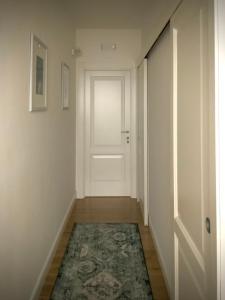 an empty hallway with a white door and a rug at La luna nel pozzo in Botrugno