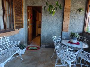 een patio met een tafel en stoelen en een deur bij Flats Brancas Nuvens in Campos do Jordão