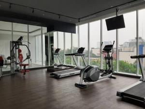 a gym with several treadmills and elliptical machines at Apartemen Altiz Bintaro J in Mencil