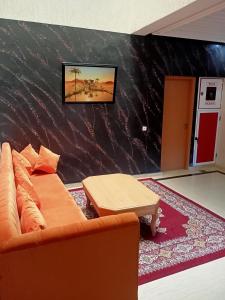 Hotel Tidinit في كلميم: غرفة معيشة مع أريكة وجدار أسود
