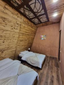zwei Betten in einem Zimmer mit Holzwand in der Unterkunft DilijAnYan-Guesthouse1 in Dilidschan