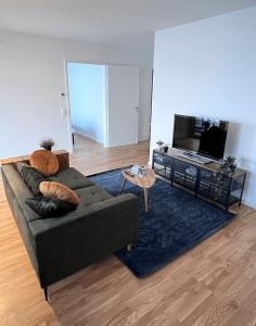 un soggiorno con divano e TV di Moderne Wohnung mit Loggia - Neubau 2023 a Bergisch Gladbach