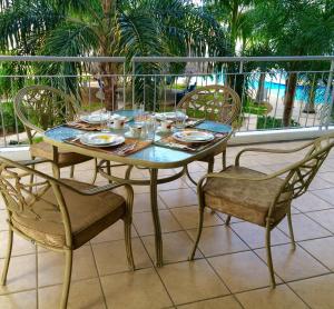 una mesa y sillas en un balcón con palmeras en Condominio c/ alberca y vista a Marina Mazatlán, en Mazatlán