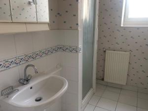 ein weißes Bad mit einem Waschbecken und einer Dusche in der Unterkunft Gîte -Belle Maison dans une ancienne école-Tarif réduit hors WE ! in Chanzeaux