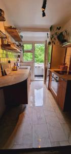 a kitchen with a large tile floor and a counter at Bright Cosy 1 Bed Apartment, SE London in Chislehurst