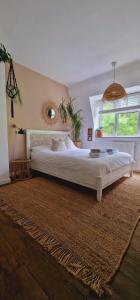 een slaapkamer met een groot bed en een raam bij Bright Cosy 1 Bed Apartment, SE London in Chislehurst