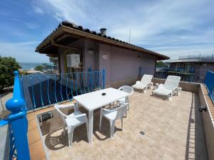 eine Terrasse mit einem weißen Tisch und Stühlen auf dem Dach in der Unterkunft Camping Gradina Garden Beach b33 in Tschernomorez